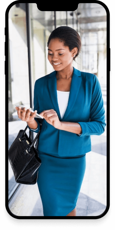 A business woman texting on her phone and smiling.