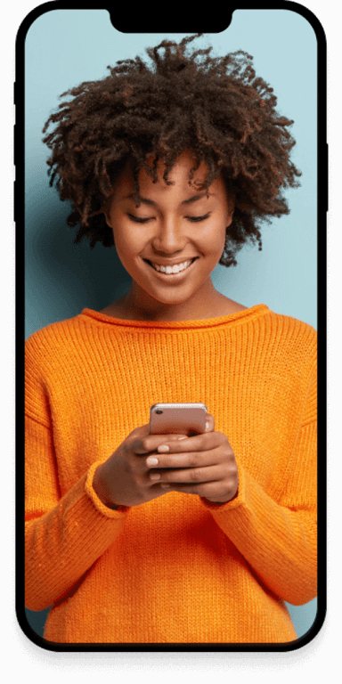 A woman smiling at a text message she received.