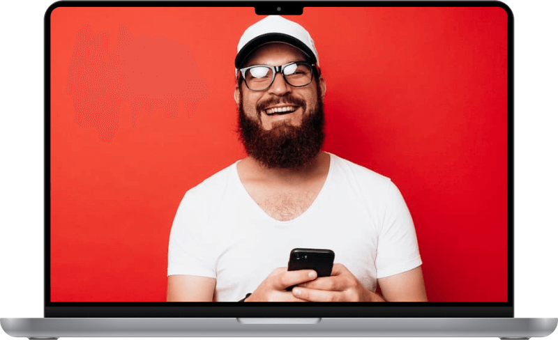A man smiling and holding a cellphone.