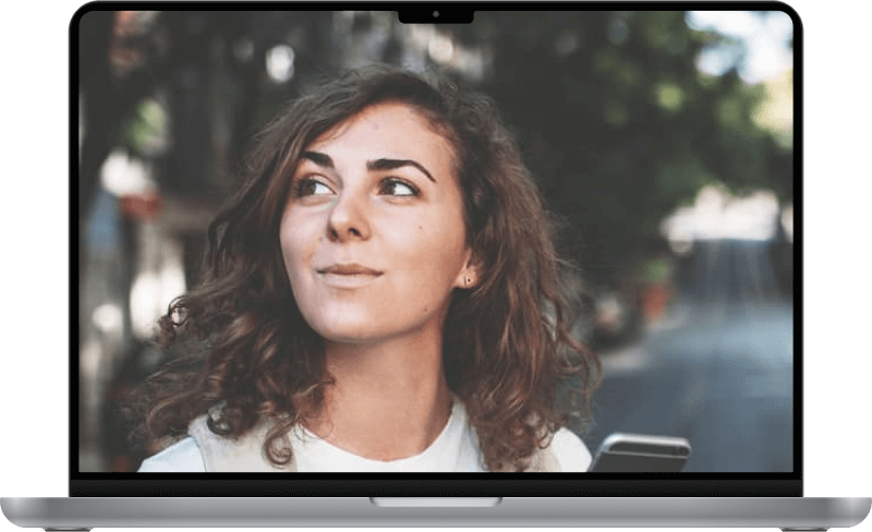 A woman looking up from cellphone with a smirk.
