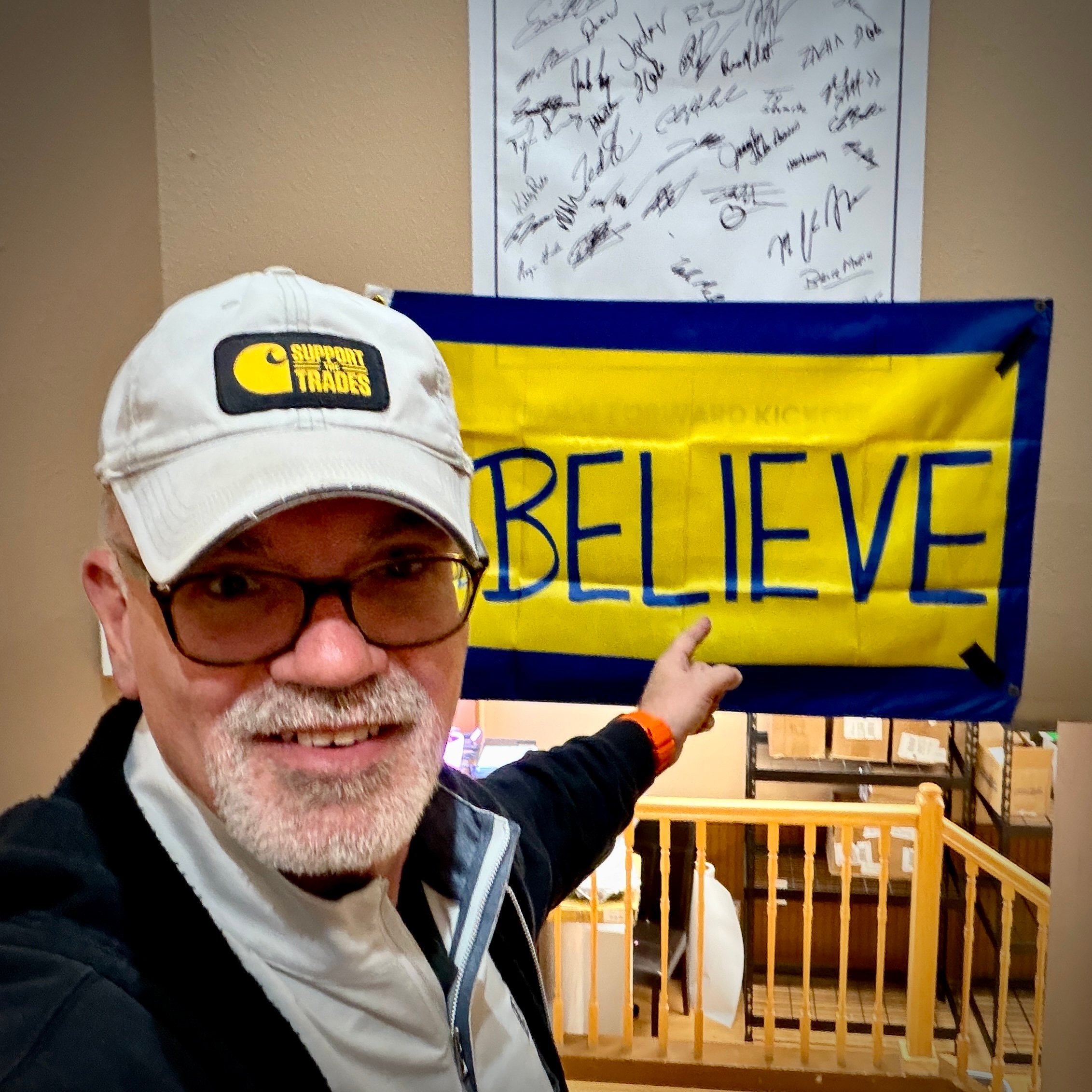 Bruce Peter Morin pointing at a BELIEVE sign at UFP Site Built Lafayette, Colorado plant