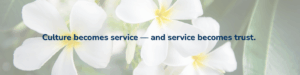 White plumeria flowers behind the message “Culture becomes service — and service becomes trust,” representing International Bridge’s Aloha-driven culture.
