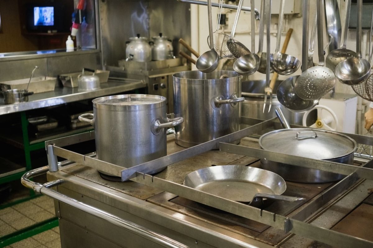 Commercial kitchen equipment pots and pans on stove