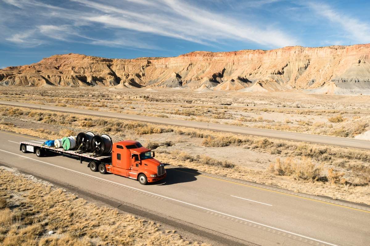 Over The Road Long Haul 18 Wheeler Big Rig Truck Flatbed Hot shot trucking - semi truck hauling freight on highway