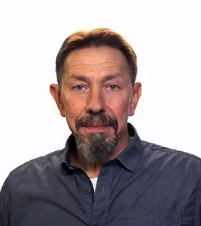 Portrait of a bearded man against a plain white background