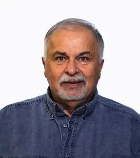 Portrait of an older man with gray beard against a white background