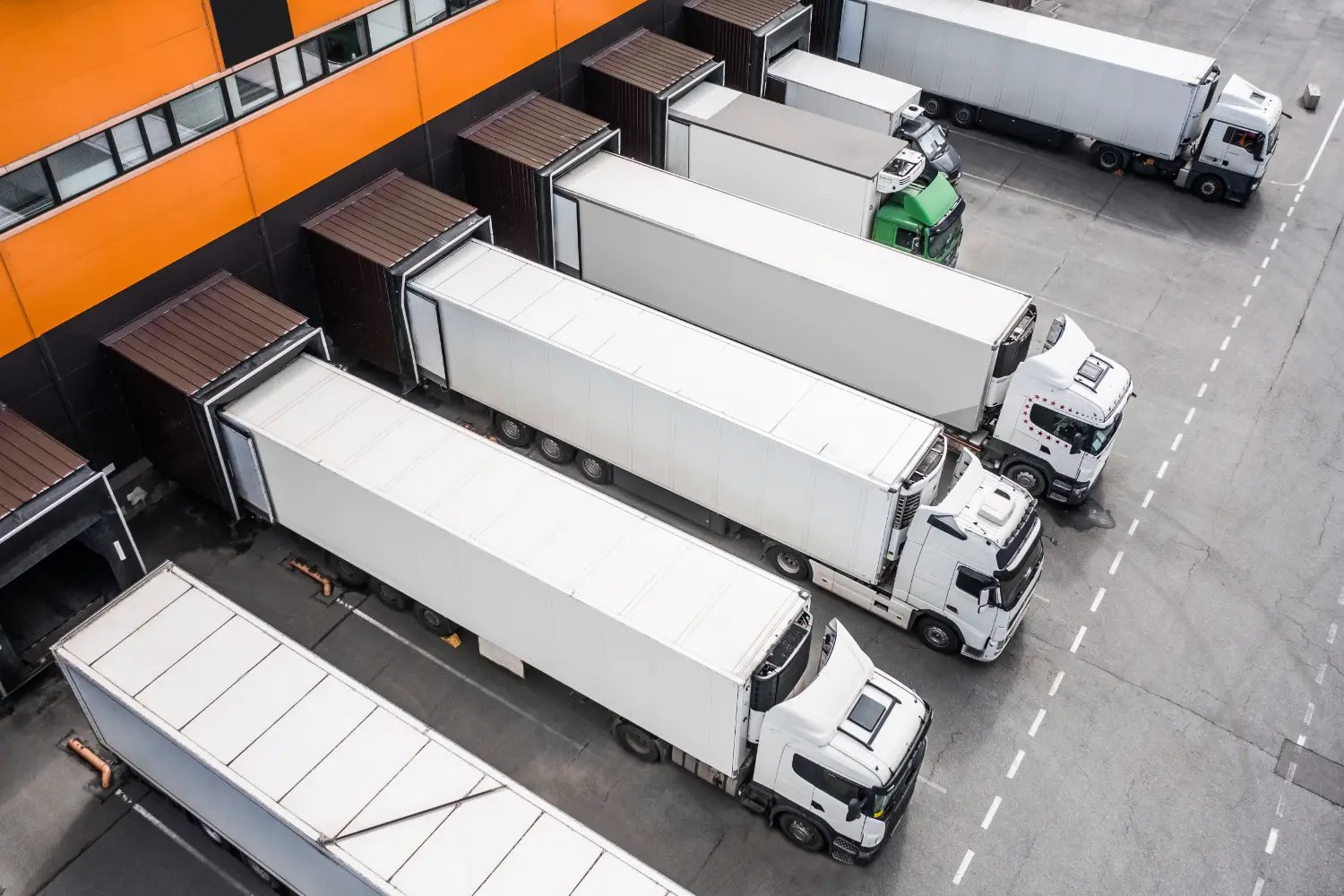 exp-logistics-hub Semi trailers docked at the loading bays of a busy distribution centre, seen from above