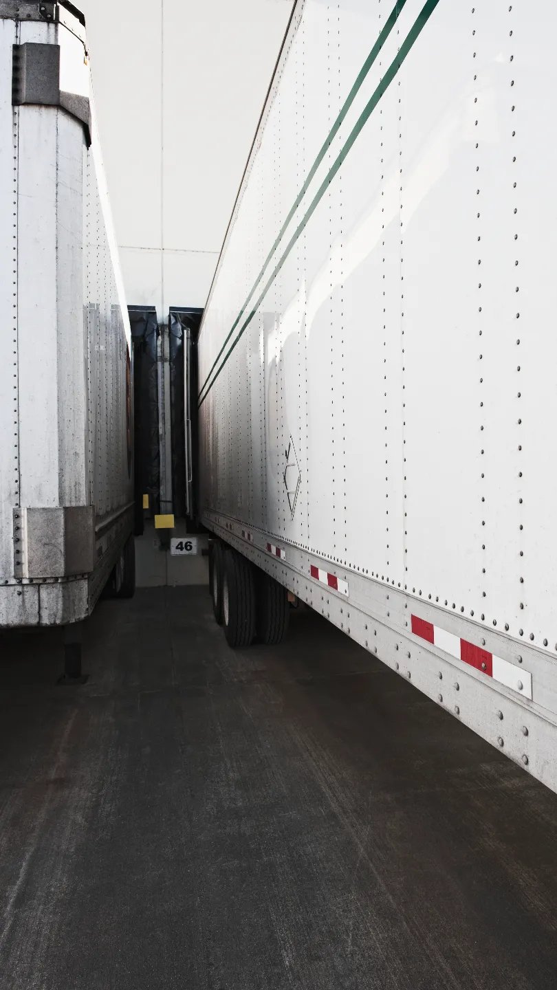 expedited-logistics White dry van trailers backed in side by side at dock bay 46 awaiting expedited freight