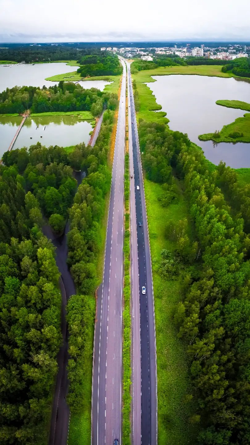 fast-shipping1 Aerial view of a divided highway cutting through forest and lakes toward a city skyline