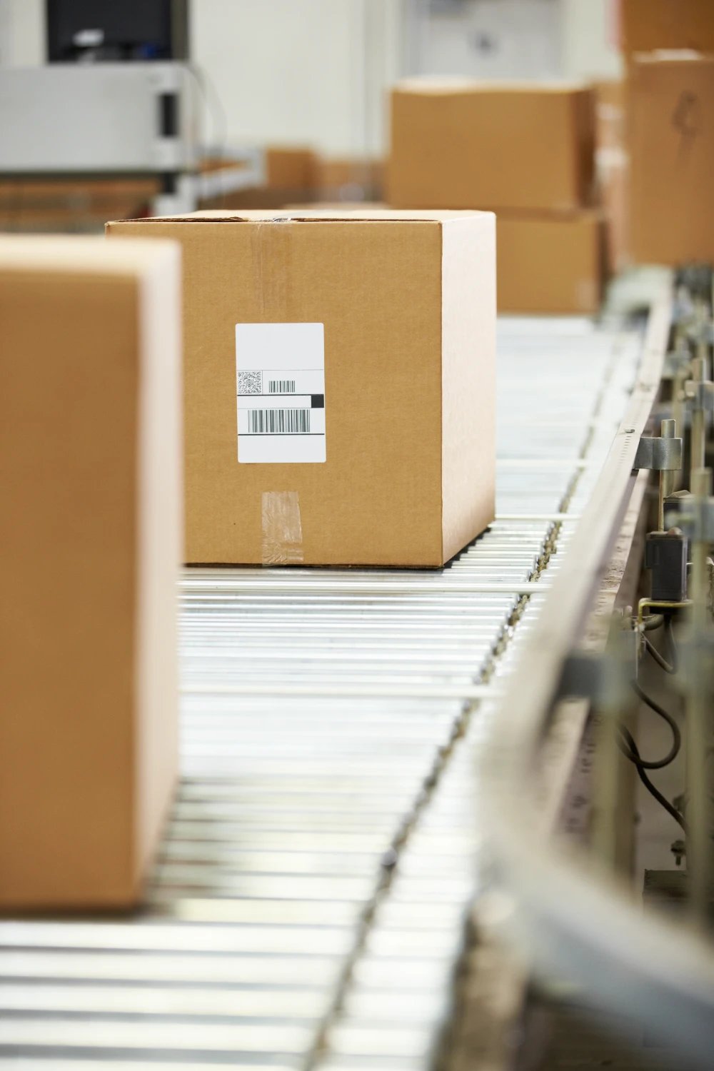 Barcode-labelled parcel moving along a roller conveyor in a sorting facility