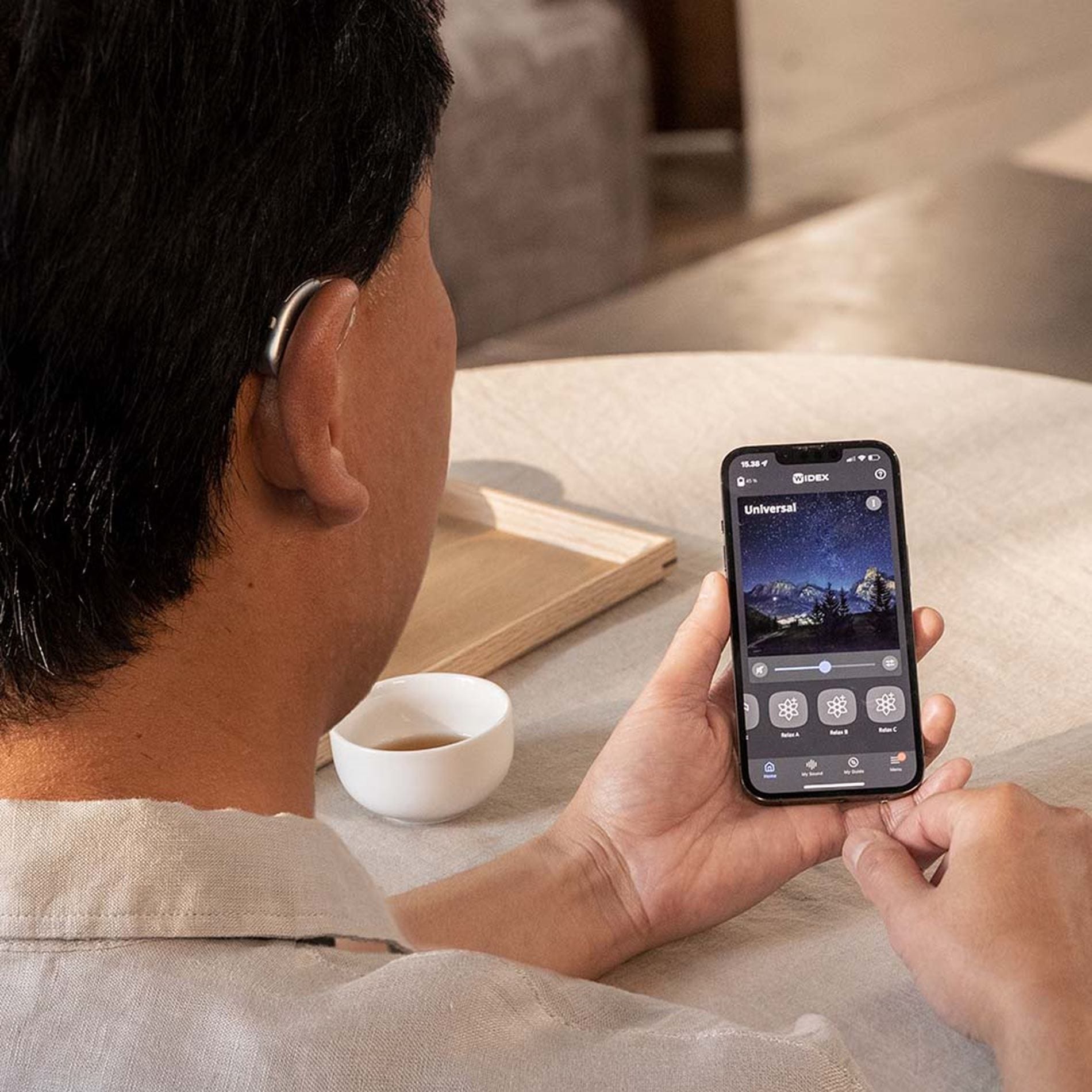  moment sheer mysound cafe man smartphone sric hearing aids from behind 1000x1000 moment sheer sric r d   the audiology place