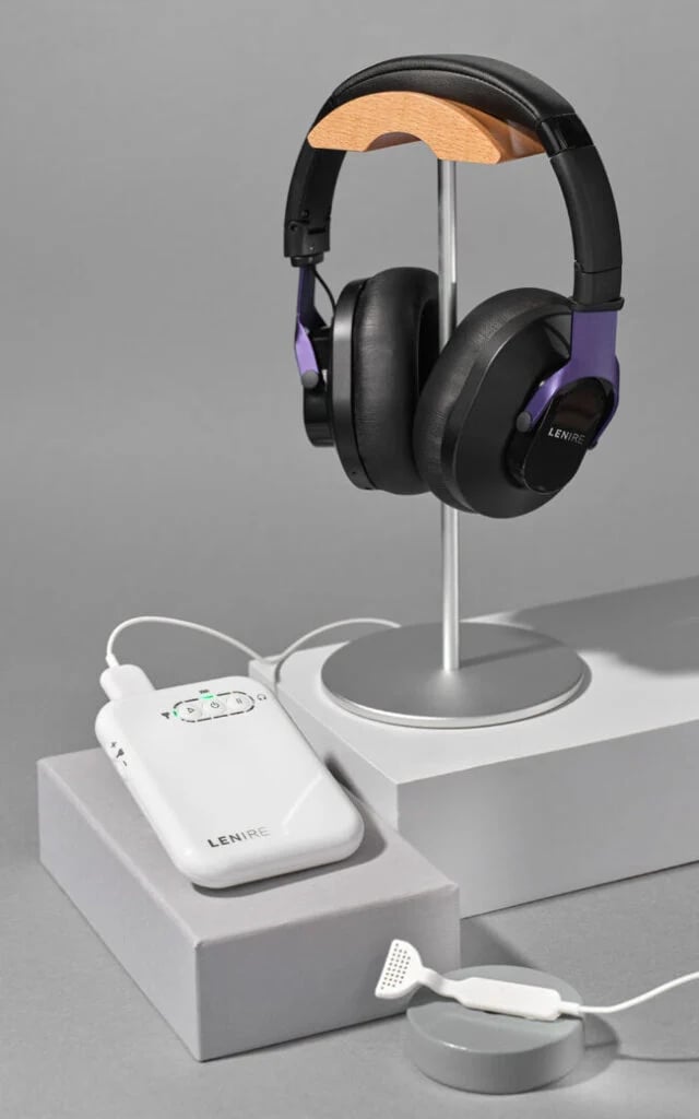over ear headphones on a metal stand beside a white lenire control unit on a gray surface lenire tinnitus technology 640x1024 lenire tinnitus treatment the audiology place