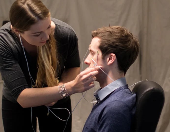 researcher attaches electrode wires to a mans face for a neurological test or measurement session lenire trials lenire provider the audiology place