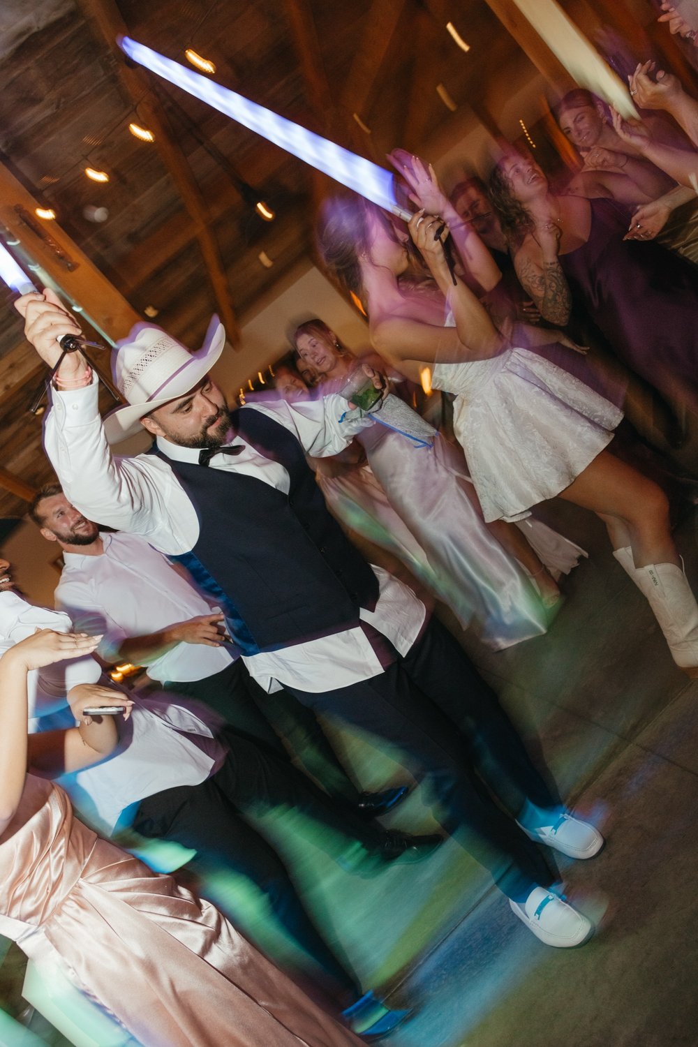 Packed barn dance floor with glow sticks at a Colorado wedding — Photo: Chloe Noelle