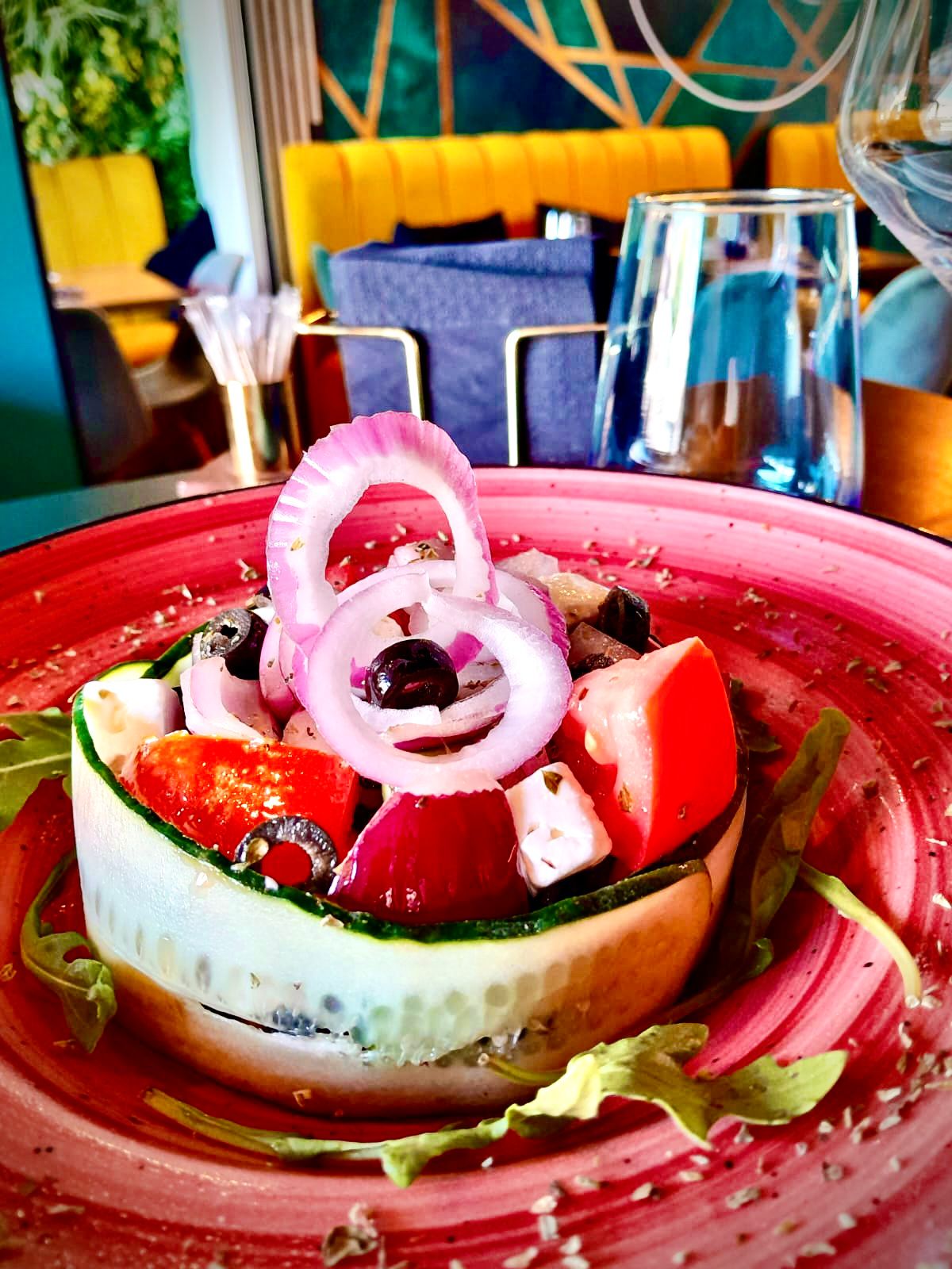 Ensalada griega, tomate, pepino, cebolla morada, aceitunas, queso feta y oregano con vinagreta de miel y lima