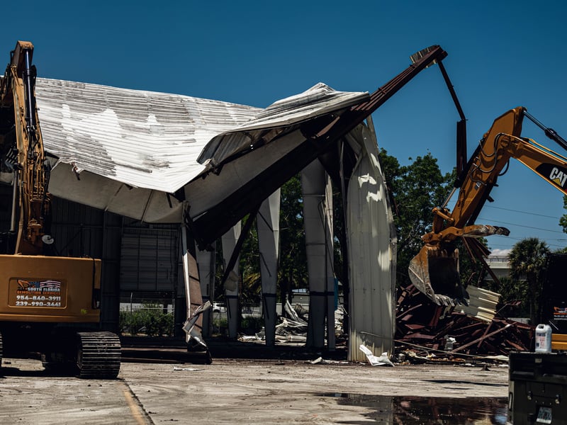 Two excavators tearing down an airport hangar at Boca Raton Executive Airport, 2026