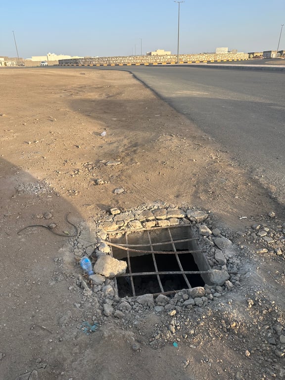 خزان أرضي مكشوف يهدد مرتادي ممشى وحديقة وملعب في عفيف. الحفرة مكشوفة ومحيطة بخرسانة وحديد ظاهري، ما يزيد مخاطر السقوط والحوادث. مطالبات عاجلة للأهالي بالتحرك الفوري من الجهات المختصة لتأمين الموقع 