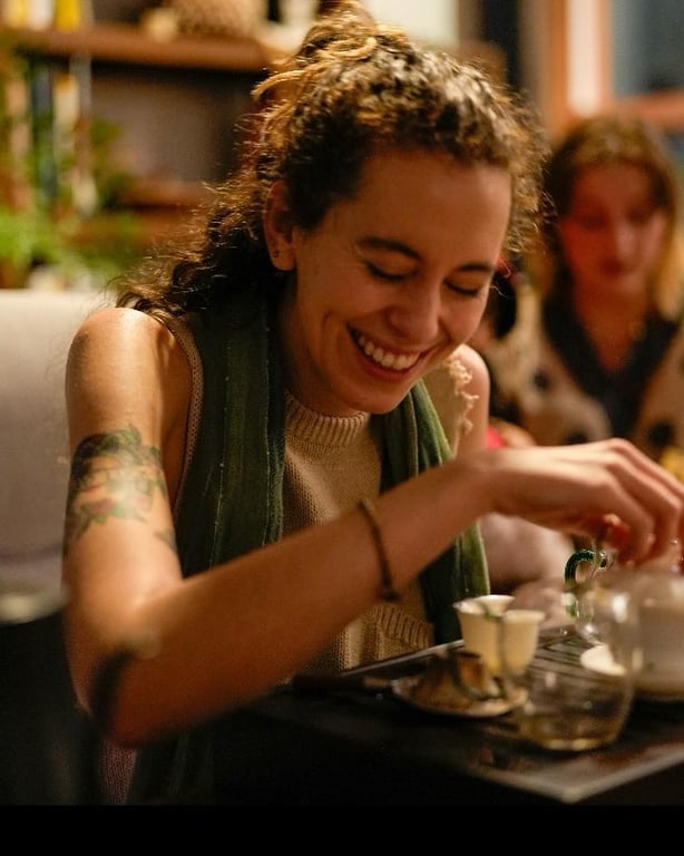 Woman laughing while pouring tea