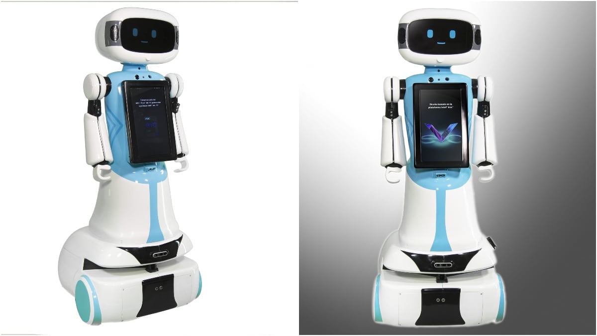 Dos aspectos del mismo robot, uno de tres cuartos y otro de frente. Es un robot de estructura blanca, con algunas franjas azules que marcarían el tronco y las piernas. En la parte frontal tiene una tableta negra, mismo color que lleva en el visor de la cara, donde destacan dos luces azules que se ven como ojos. En la base del robot hay un cilindro que le permite deslizarse por el suelo.