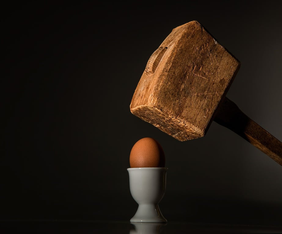 Mazo de madera a punto de romper un huevo.