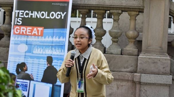 Estrella Salazar con uniforme escolar exponiendo en una conferencia de "Technology is great"