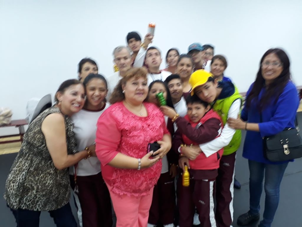 María Cristina Gutiérrez Uribe rodeada de 16 de sus alumnos felices.