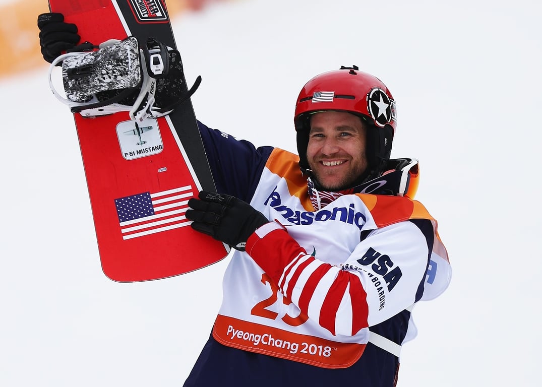 Mike Schultz sosteniendo con ambas manos un tabla de esquí con un pedal incrustado.