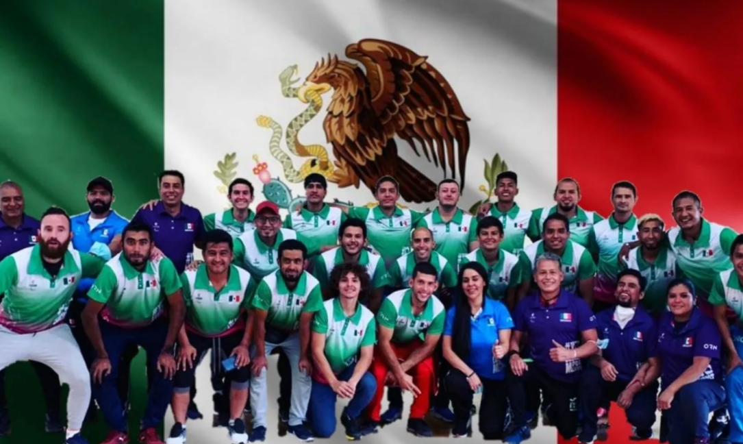 Equipo sordolímpico mexicano frente a la bandera de México.