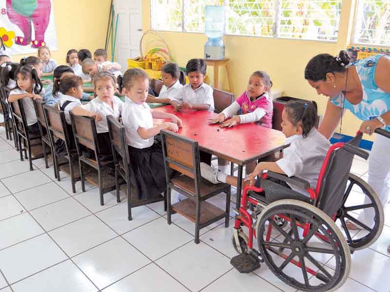 Niña usuaria de silla de ruedas en un salón de clases.