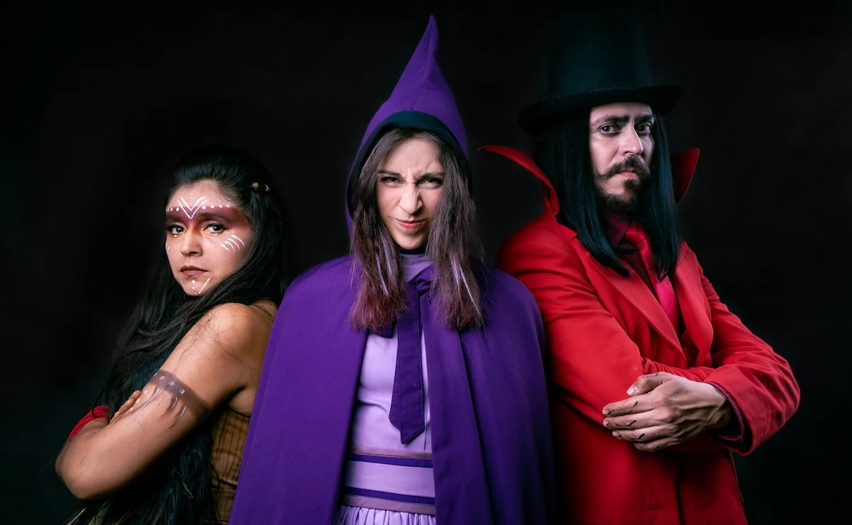 Tres actores frente a la cámara vestidos de bruja, diablo y sombra.