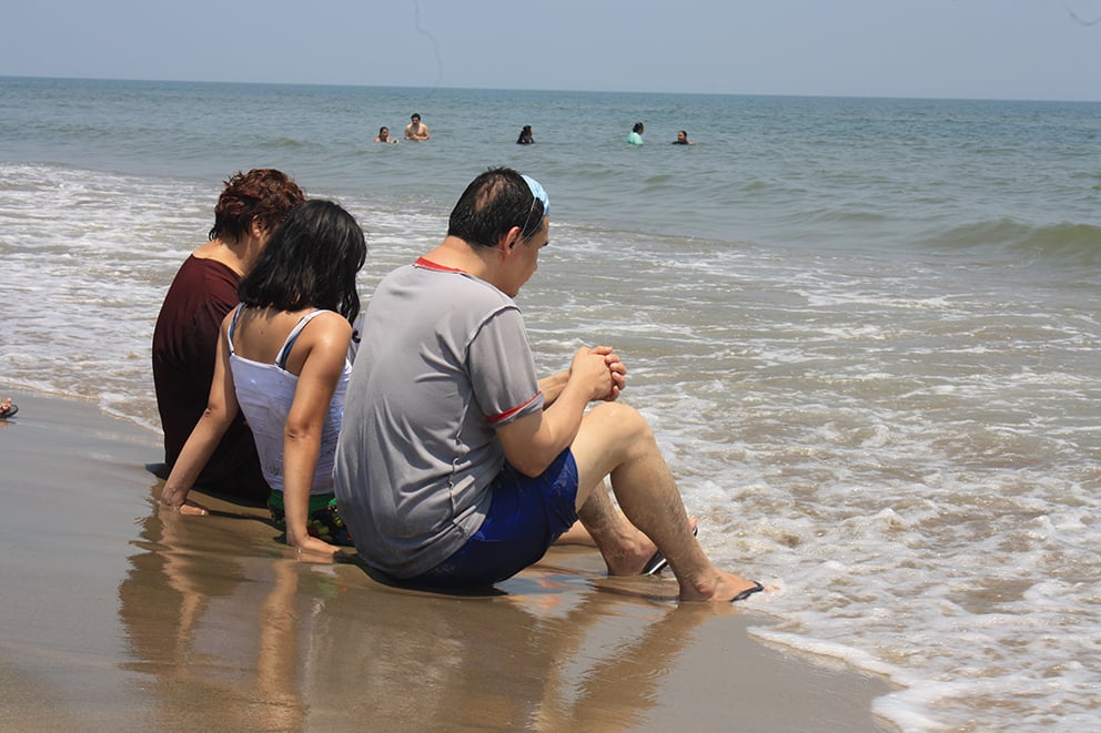 Tres pacientes psiquiátricos del Hospital de Salud Mental de Villahermosa sentados frente al mar.