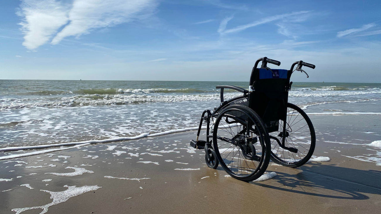 Silla de ruedas sola frente a una playa.