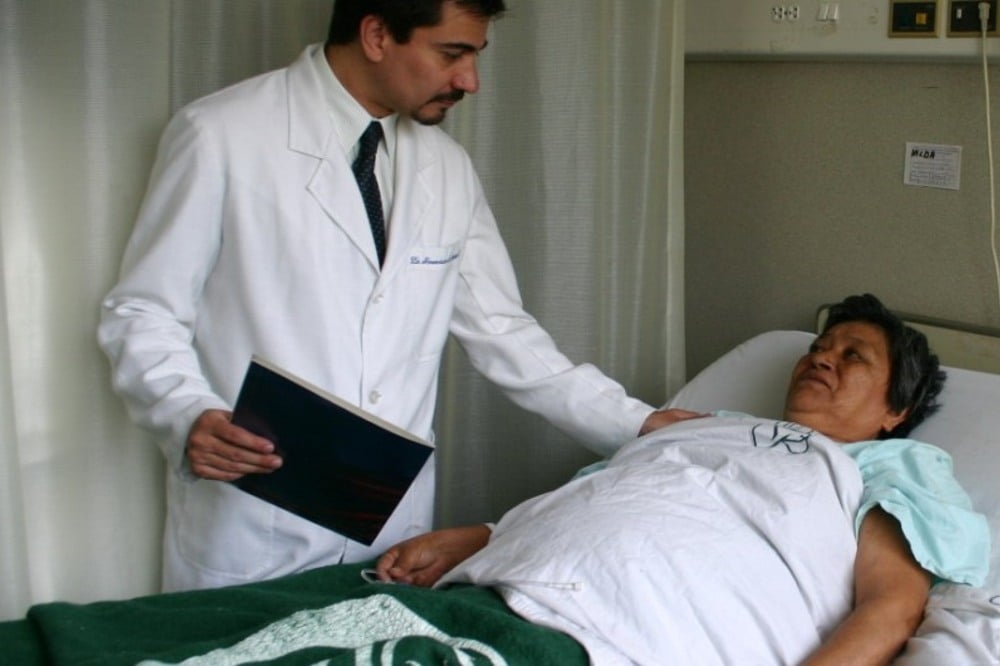 Médico tocando el hombro de una paciente.