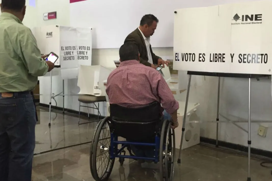 Usuario en silla de ruedas en casilla para ejercer su voto anticipado