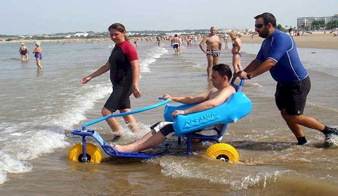 Usuario de silla anfibia en la playa.
