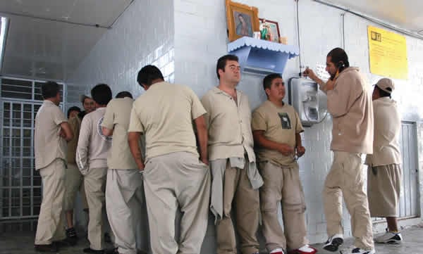 Prisioneros en un reclusorio de México haciendo fila para hablar por teléfono.