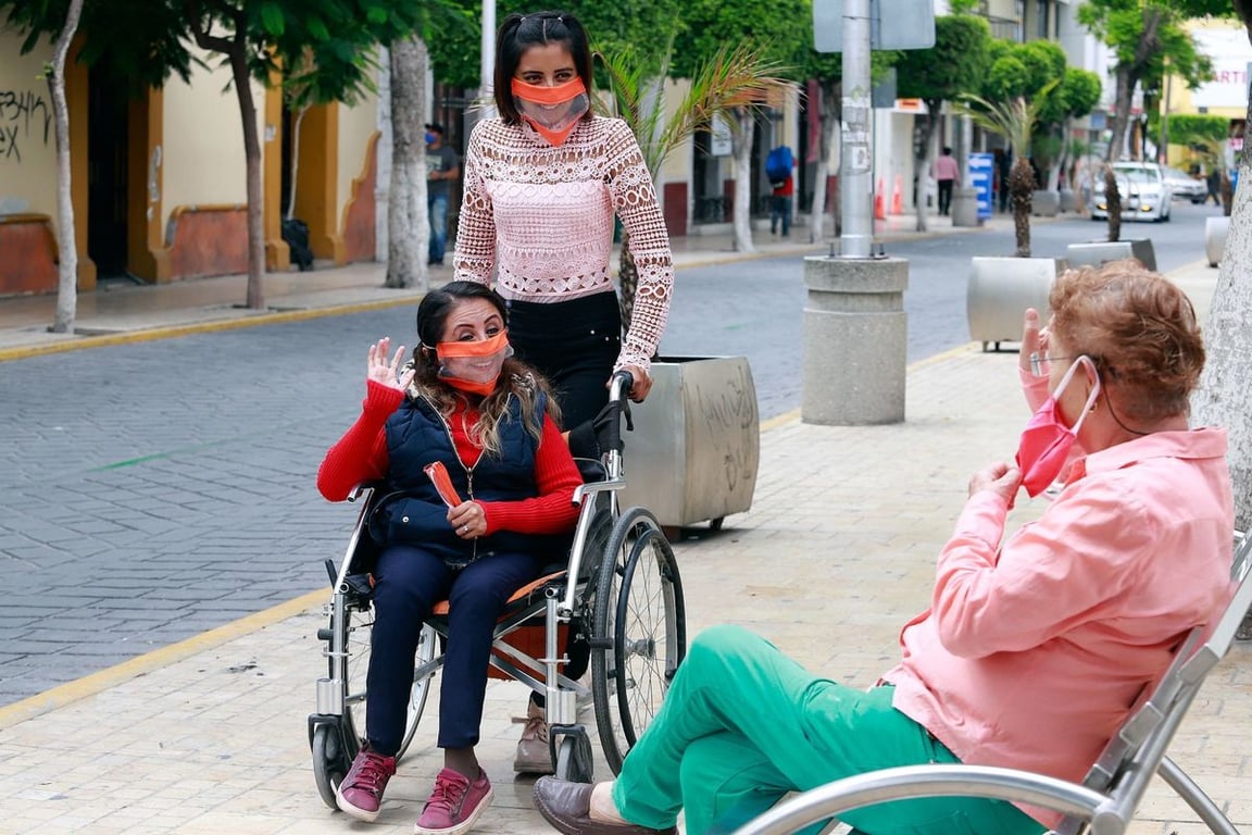 Dos cuidadoras de personas con discapacidad motriz, usuarias de silla de ruedas,