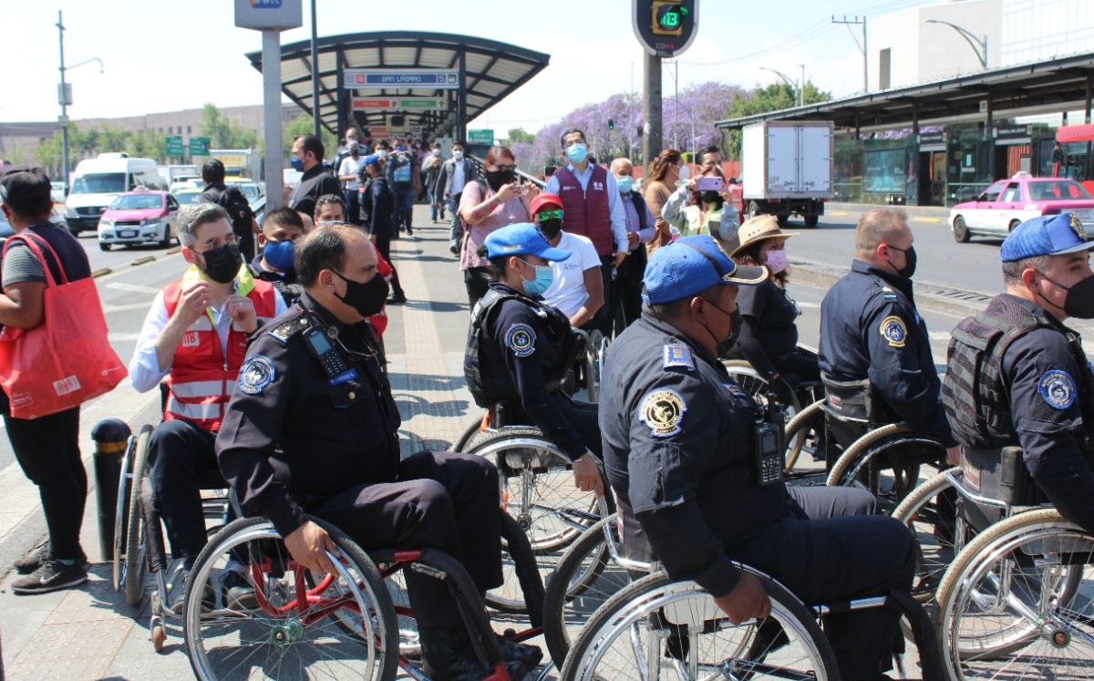 Policías del Metrobús en silla de ruedas cruzando una avenida.