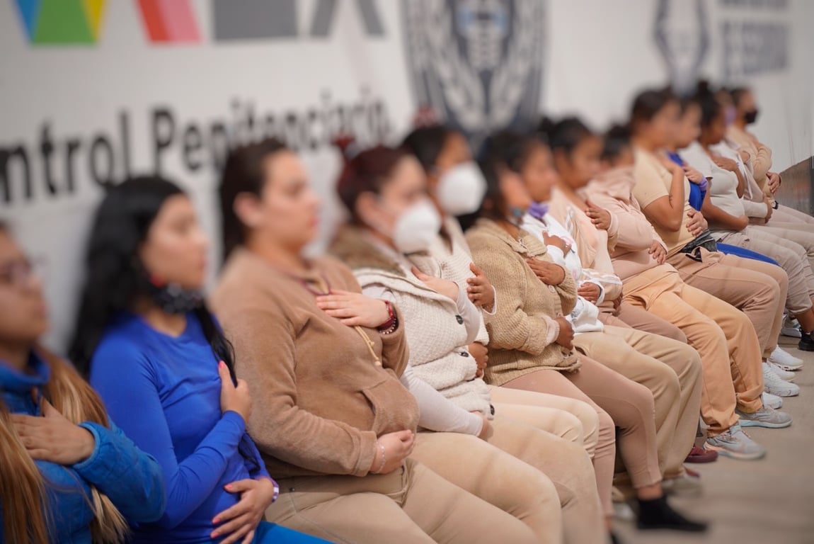 Mujeres dentro de un reclusorio, todas tienen cubierto el rostro.