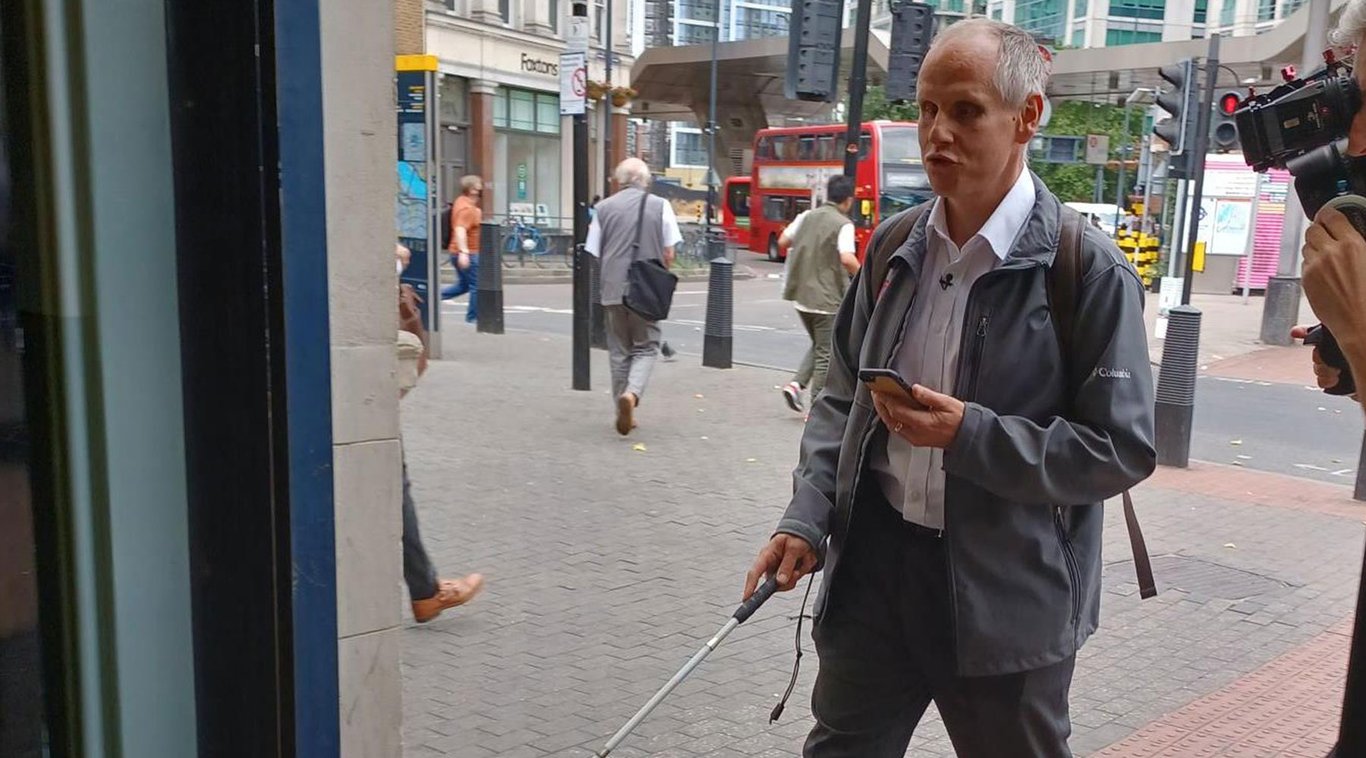 Persona con discapacidad visual abordando el tren de Londres guiado por la app myEyes