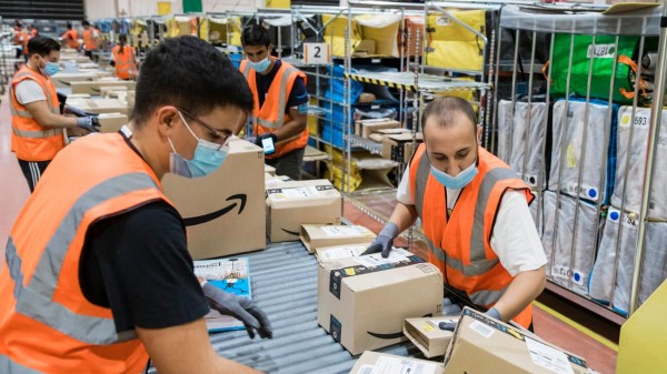 Trabajadores de Amazon empacando pedidos.
