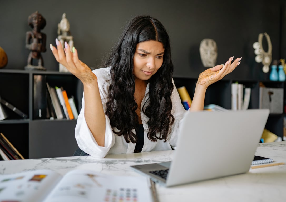 Mujer frente a su computadora con expresión de duda.