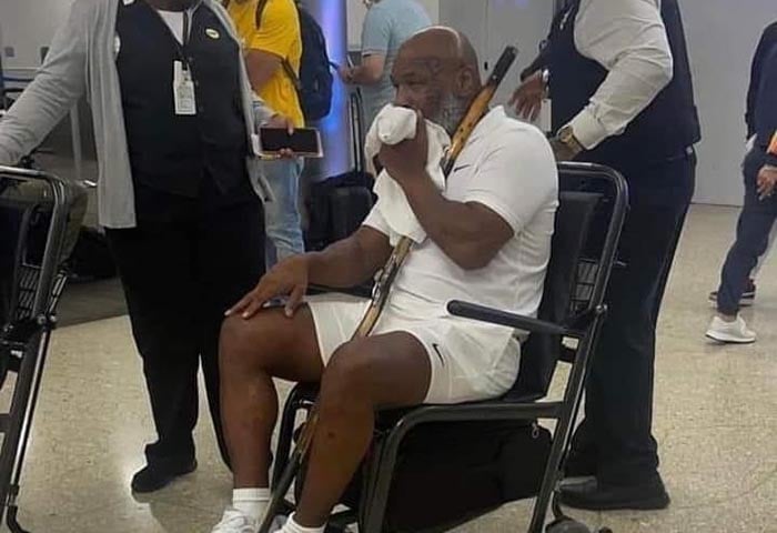 Mike Tyson en silla de ruedas secando el sudor de su rostro.