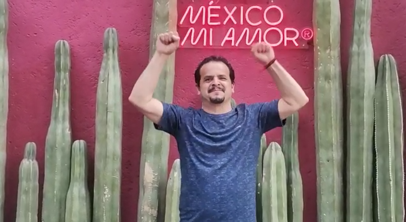 Hombre con discapacidad auditiva comunicando "Viva México" en Lengua de Señas Mexicana.