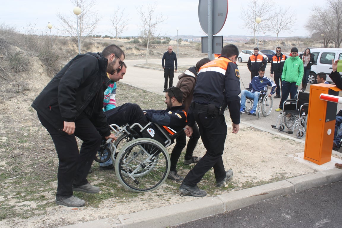 Tres personas evacuando a una pcd, en silla de ruedas.