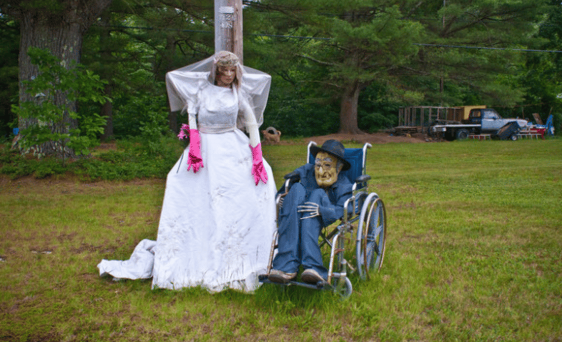 Dos figuras de cadáveres de un matrimonio biparental, una novia y un novio usuario de silla de ruedas.