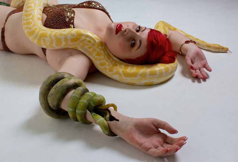 Mujer con una prótesis en el brazo izquierdo que tiene una cobra enroscada como decoración.