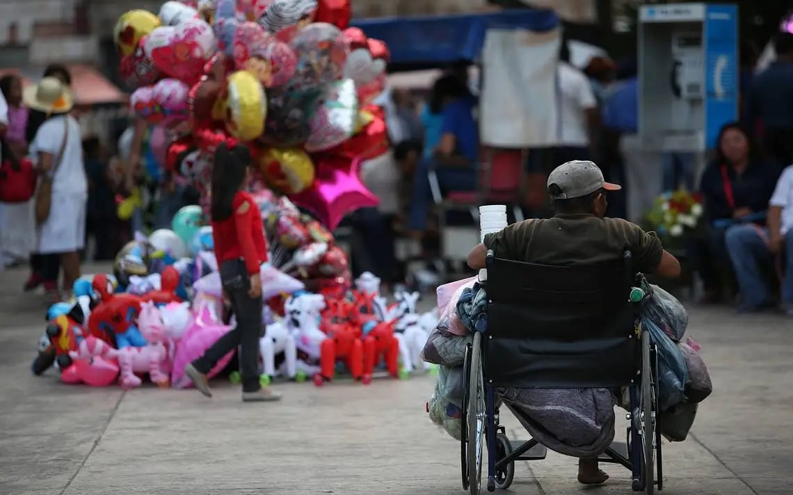 Usuario de silla de ruedas en situación de calle pidiendo dinero.