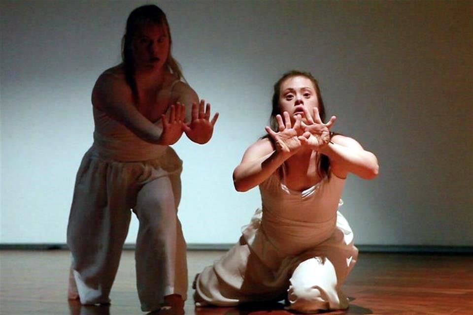 Dos mujeres con síndrome de Down bailando en un escenario.