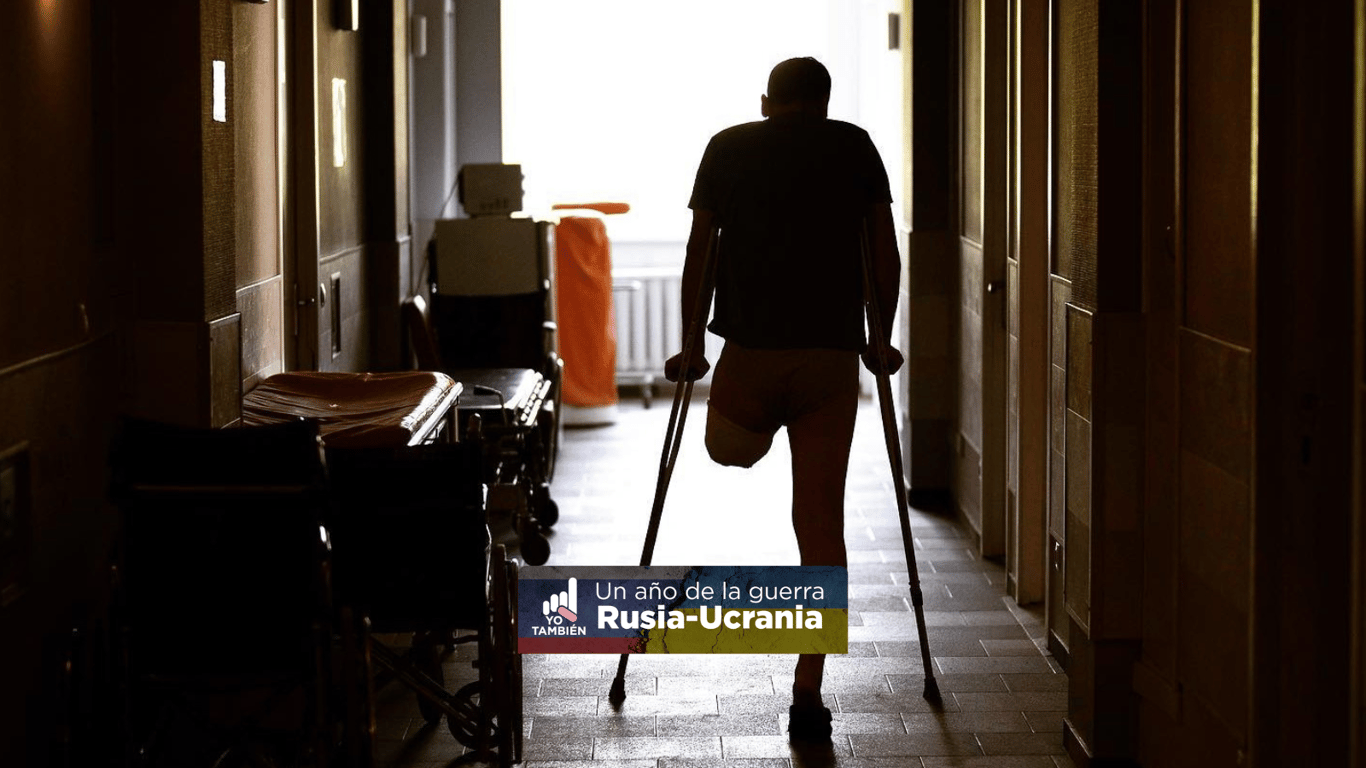 Soldado ucraniano con una pierna amputada andando en muletas por un pasillo.